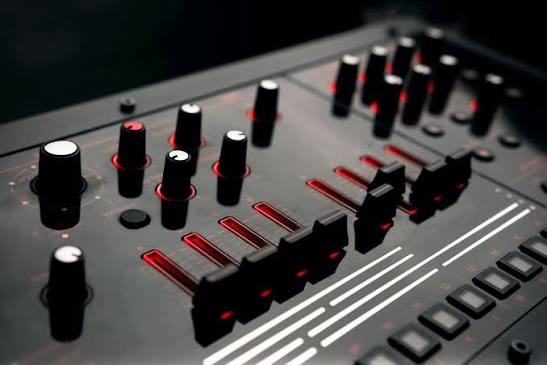 Mixing console faders lit in red