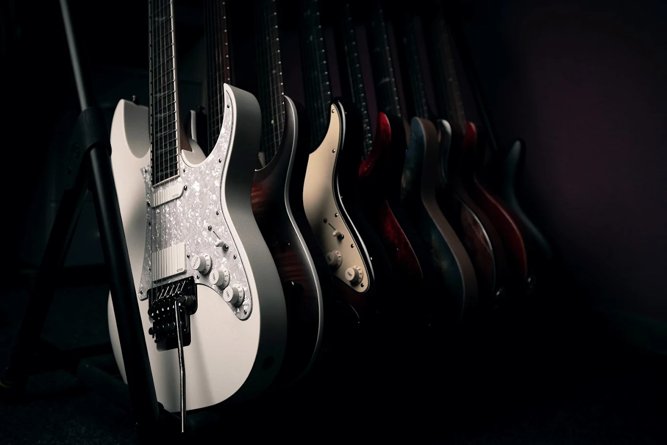 A row of electric guitars on a rack